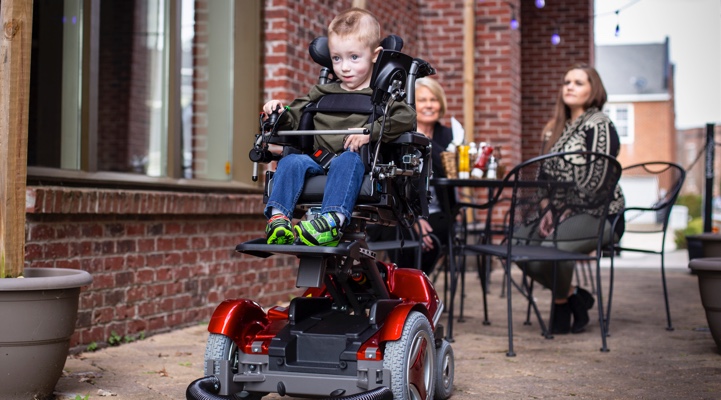 a child moving around in a wheelchair