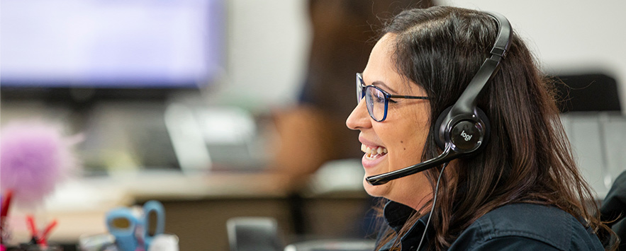 Customer service lady smiling on the phone with a customer.