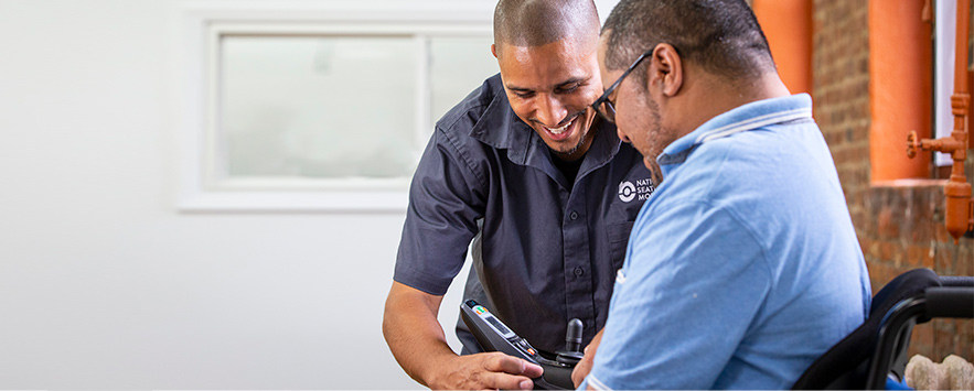 A NSM technician helping a customer set up his power chair.