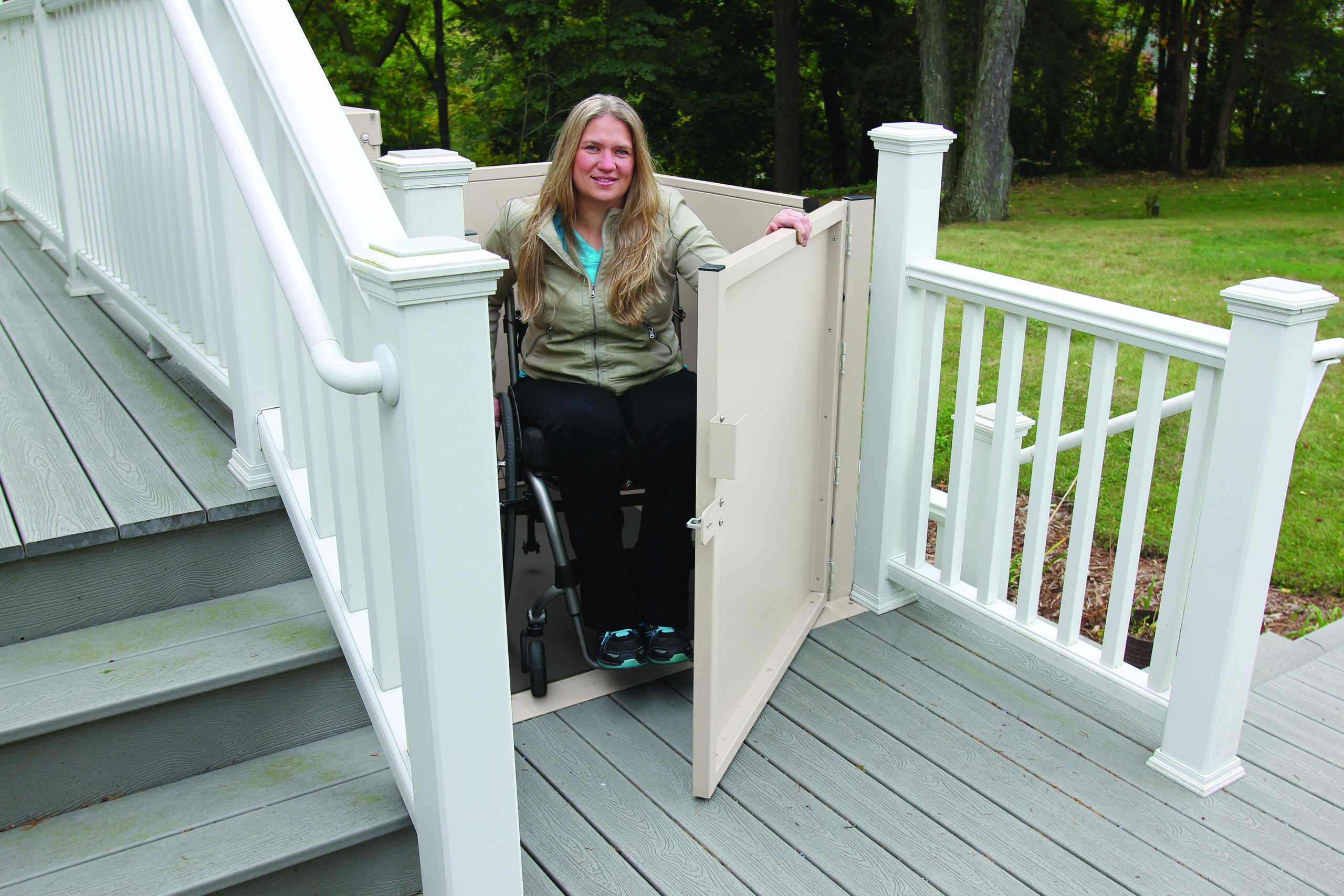 A woman outside using the Bruno Residential Vertical Platform Lift to get up and down stairs in a wheelchair