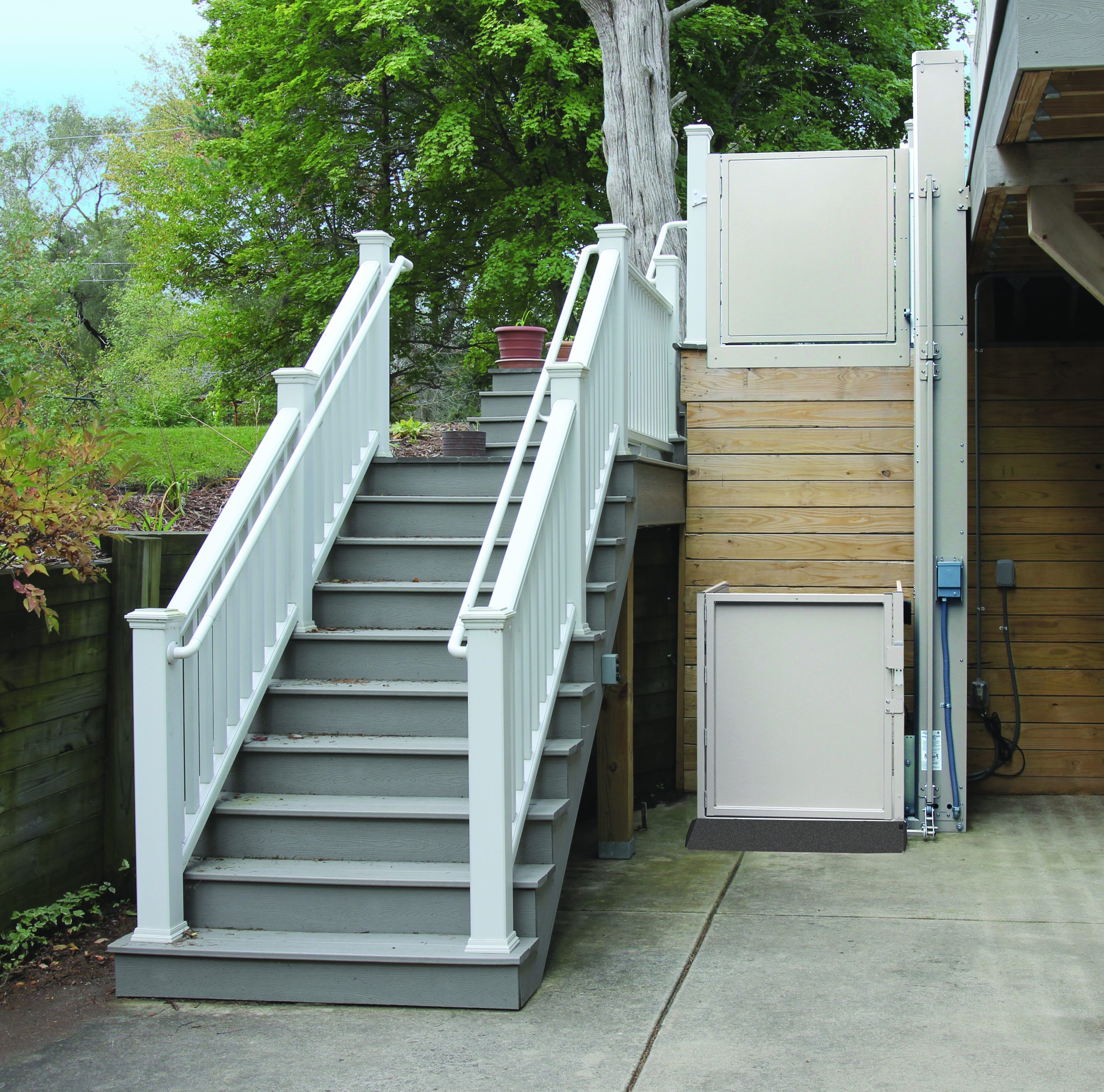 The Bruno Residential Vertical Platform Lift installed beside stairs outside