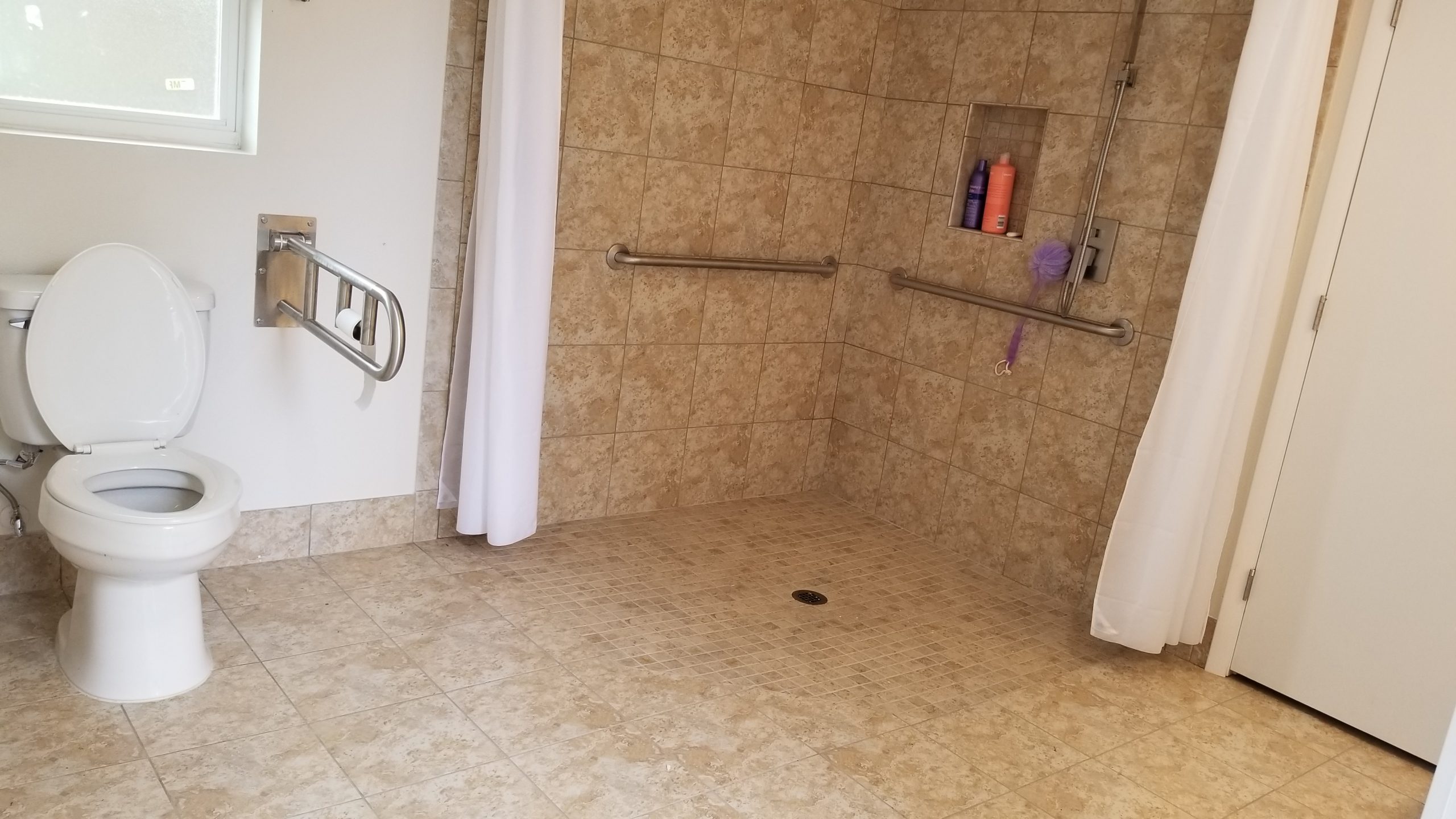 A bathroom with a grab bar installed in the shower