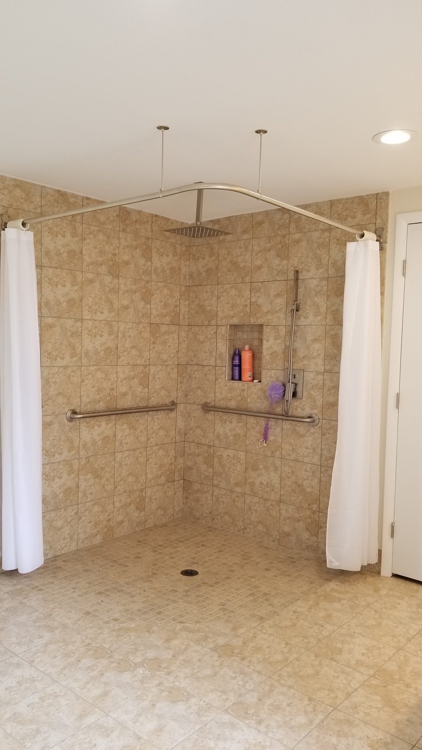 A bathroom with a grab bar installed in the shower