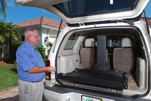 A man standing beside a car with a platform list