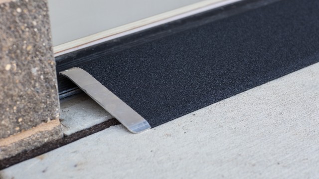Black angled entry plate in front of a cement entry