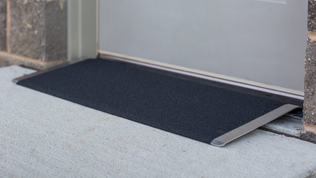 Black angled entry plate in front of a door