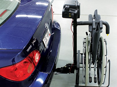 A side view of the Bruno Back Saver as it lifts a wheelchair into a car