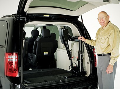 A man standing beside a Big Lifter that's packed into his car