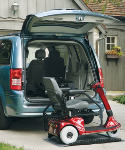 A scooter in front of a van