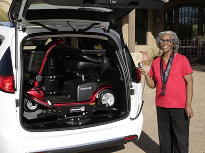 A woman showing a scooter in a van