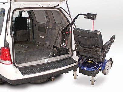 A lifter lifting a wheelchair into a car