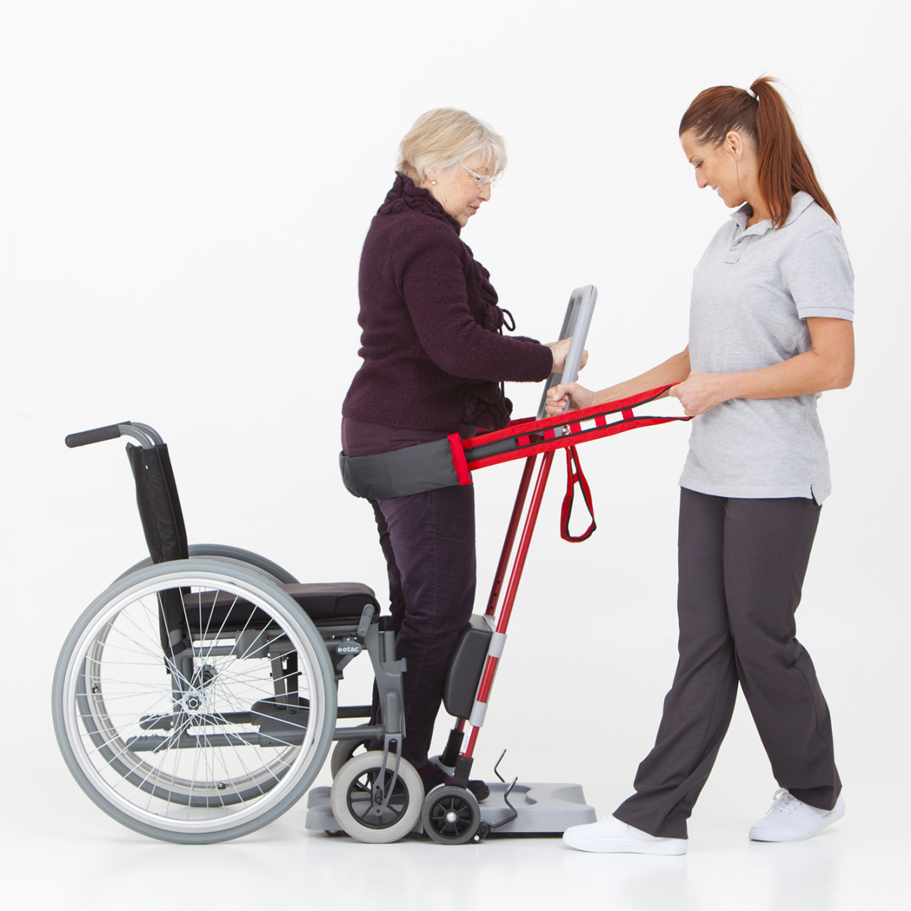 Two woman using a raiser to utilize a wheelchair