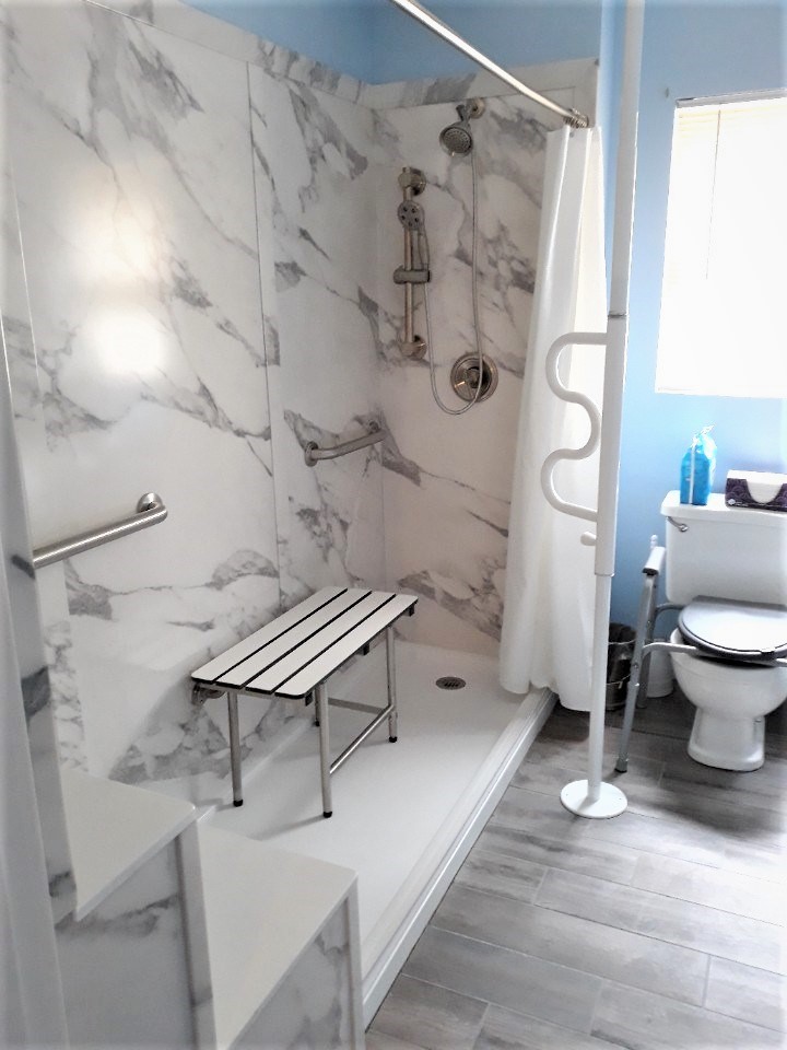 A bathroom with a grab bar installed in the shower