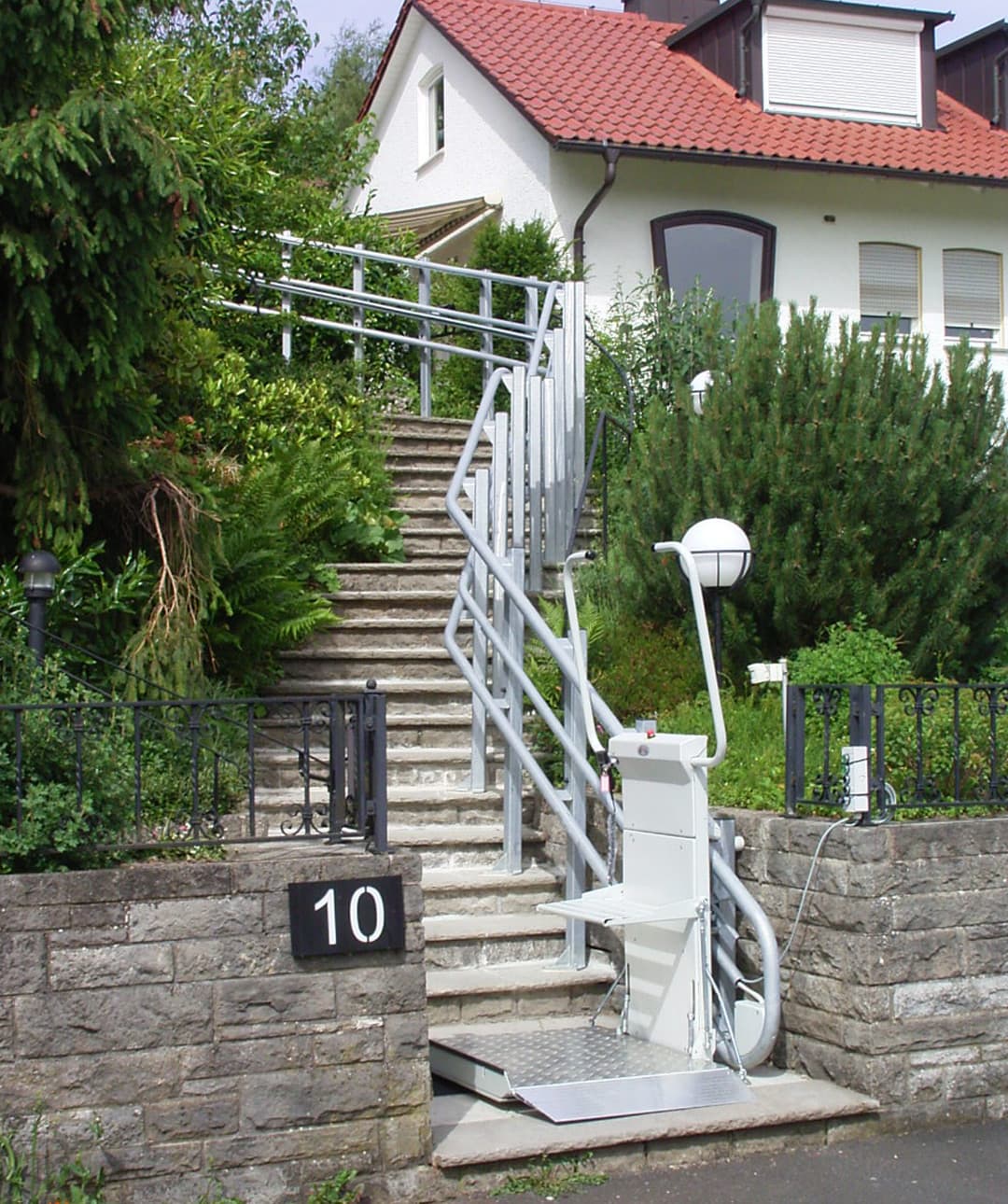 A platform lift leading up outdoor stairs to a house