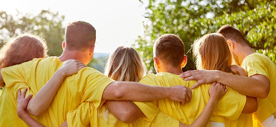Young strong team hugs each other at a team building event in na Young strong team hugs each other at a team building event in nature